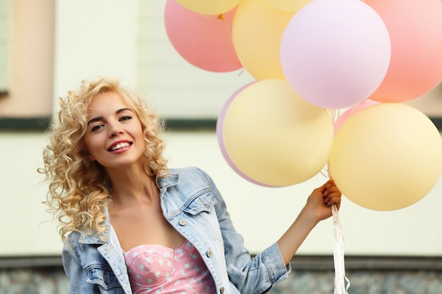 Foto mooie jonge vrouw met luchtballonnen op straat