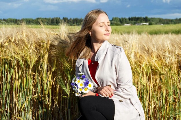 Mooie jonge vrouw met ogen gesloten door planten.