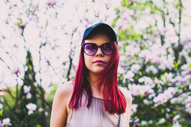 Mooie jonge vrouw met roze haar en sensuele blik in het park in de zomer