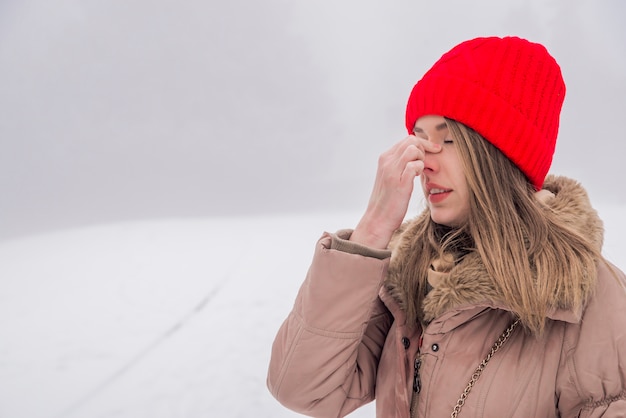 Mooie jonge vrouw met sinus druk pijn. Sinus pijn, sinus druk, sinusitis. Droevige vrouw die haar neus houdt omdat sinuspijn