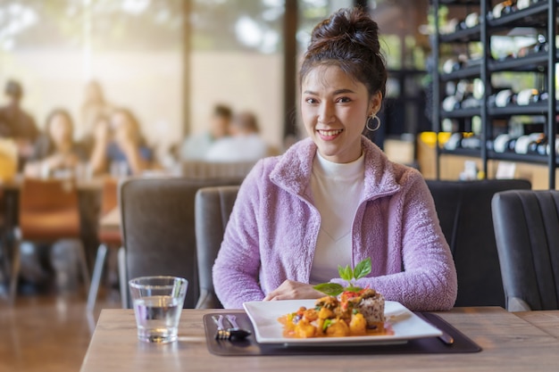 Mooie jonge vrouw met voedsel in restaurant