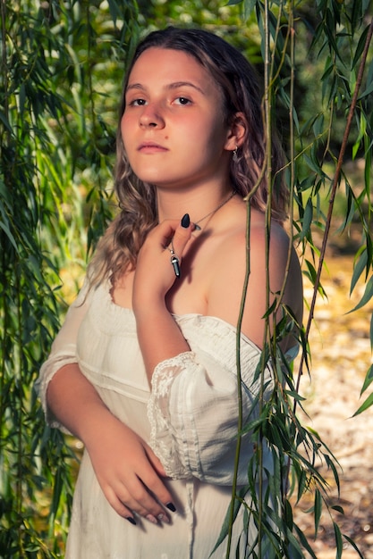 Mooie jonge vrouw met witte jurk in de buurt van stroom van water.