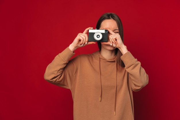 Mooie jonge vrouw oefent haar hobby uit en maakt een foto met haar camera