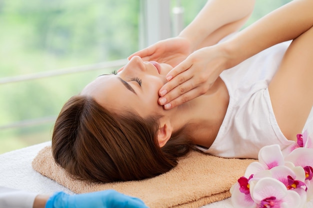 Mooie jonge vrouw ontspannen met handmassage in beauty spa salon