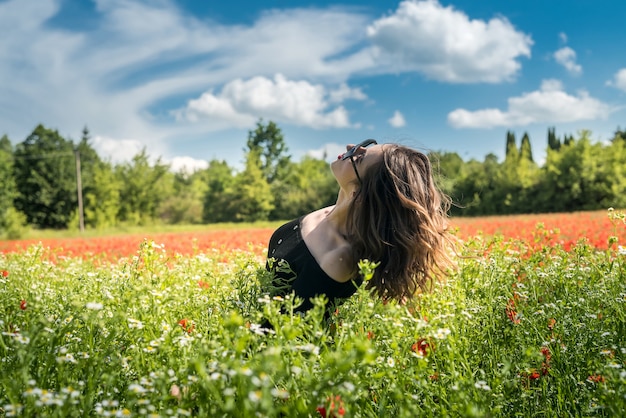 Mooie jonge vrouw op gebied van bloemen madeliefjes, geniet van de natuur. zomertijd