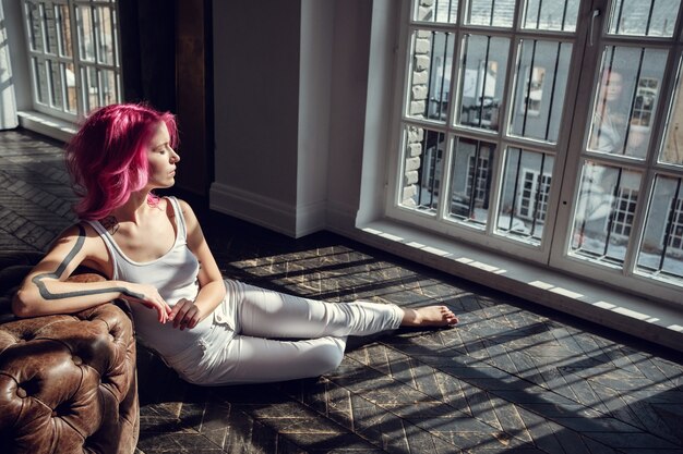 Mooie jonge vrouw poseren in fotostudio met natuurlijk licht. Jong en sexy