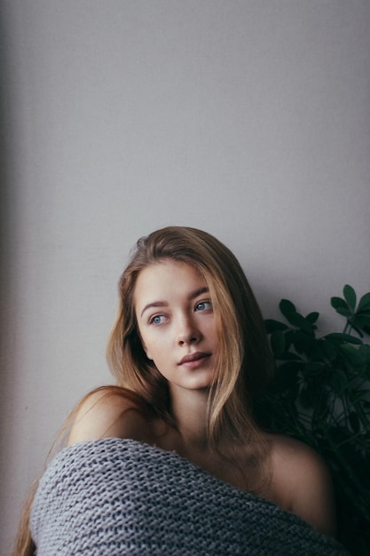 Mooie jonge vrouw tegen de muur thuis.