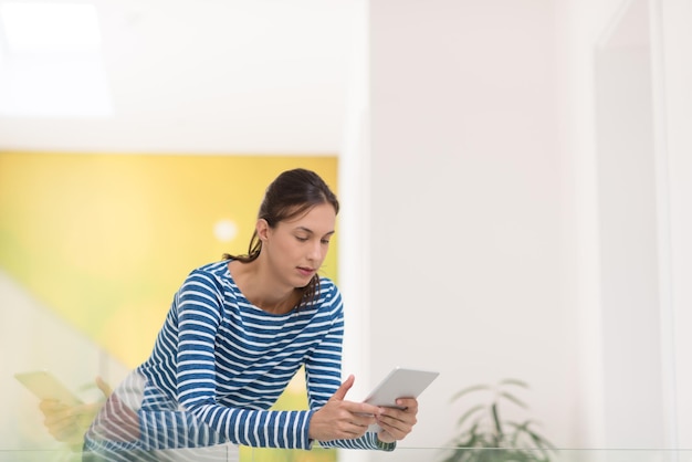 mooie jonge vrouw thuis websurfen op internet met tablet