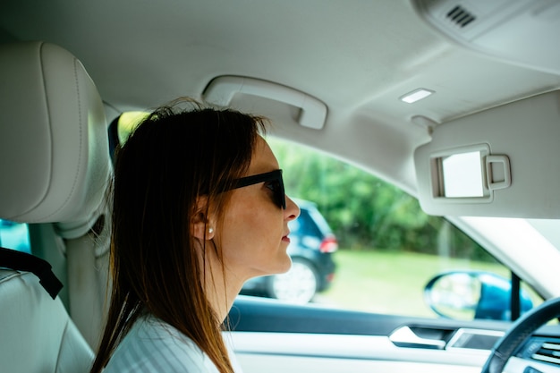 Foto mooie jonge vrouw van middelbare leeftijd rijden serieus dragen van een zonnebril. jam. routine-