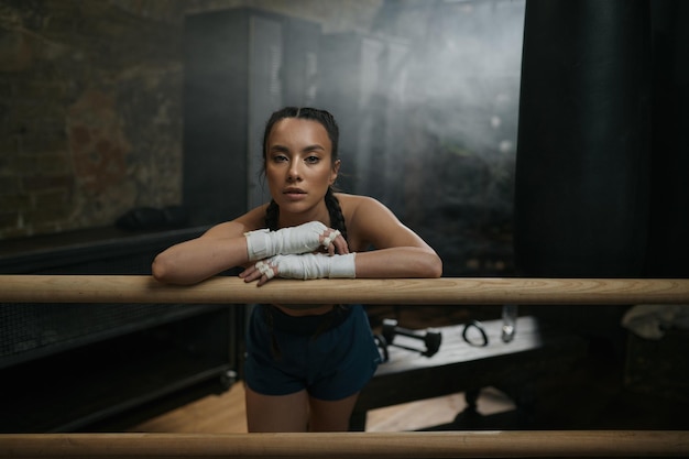 Mooie jonge vrouwelijke bokser rust in de ring klaar voor de training