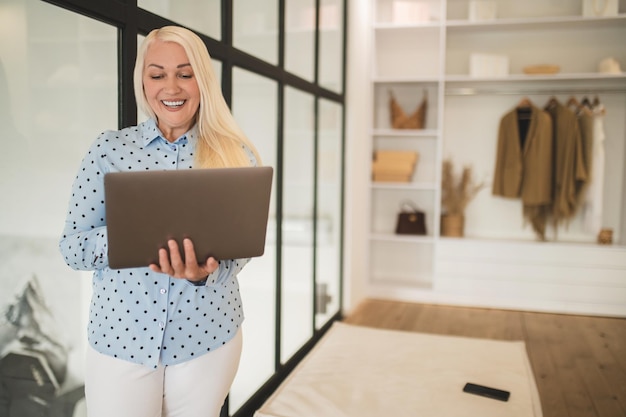 Mooie jonge zelfstandige vrouw die vanuit huis werkt