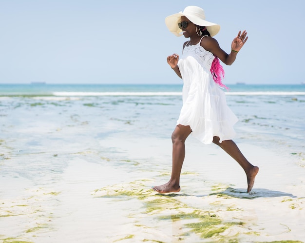 Mooie jonge zwarte afrikaanse amerikaanse vrouw op het tropische strand