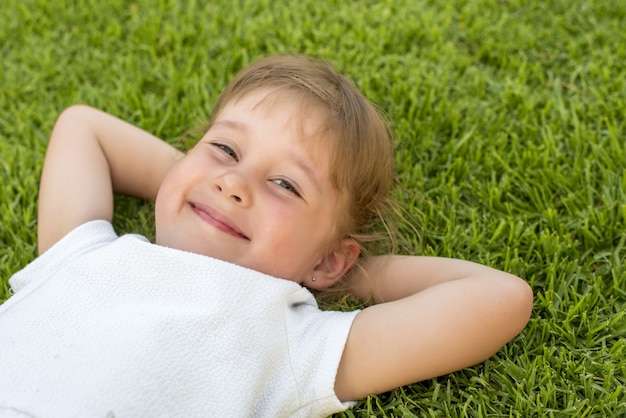 Mooie jongen die op het gras in het park ligt