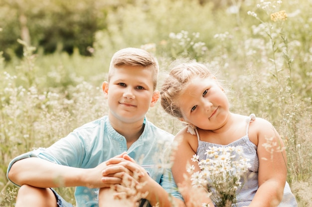 Mooie jongen en meisje in een parkjongen die bloemen geeft aan het concept van de meisjesvriendschap