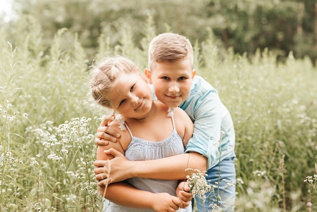 Mooie jongen en meisje in een parkjongen die bloemen geeft aan het concept van de meisjesvriendschap