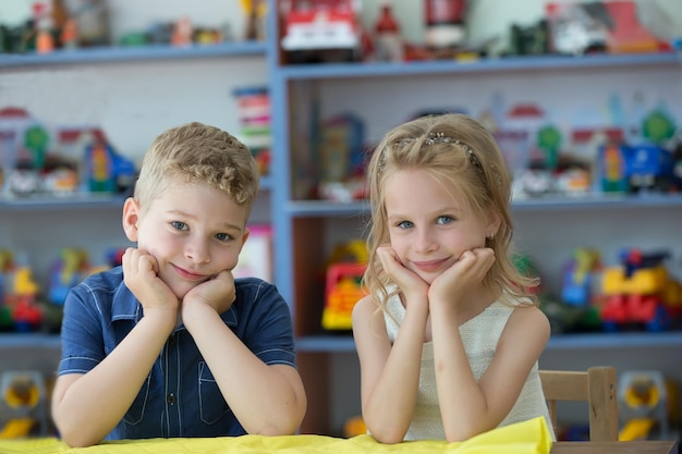 Mooie jongen en meisje op de kleuterschool Kinderen zijn kleuters Kleine broer en zus