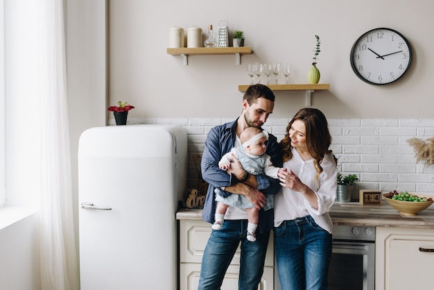 Mooie kaukasische gezin van drie in de keuken, moeder, vader en babymeisje