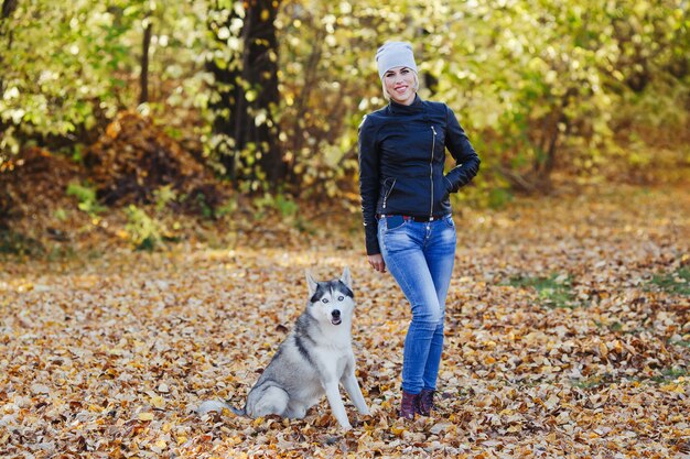 Mooie Kaukasische meisjesspelen met schor hond in de herfstbos