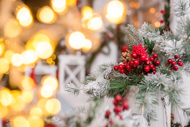 Mooie kerstachtergrond met dennentakken, rode bessen en verlichting