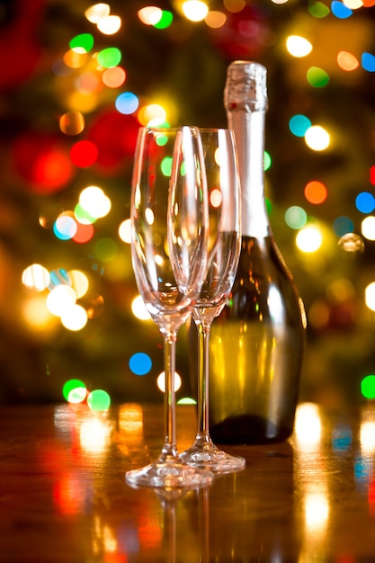 Mooie kerstachtergrond met glazen en fles champagne