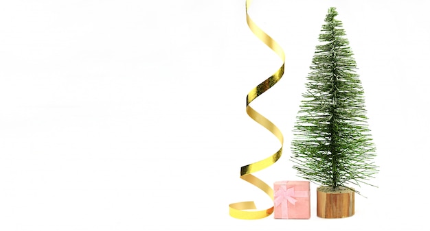 Mooie kerstboom met een gouden serpentijn lint met kleine geschenkdoos