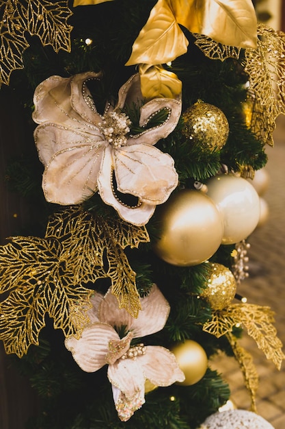 Foto mooie kerstboomversiering, gouden bloemen en ballen, lichten, feest, traditioneel