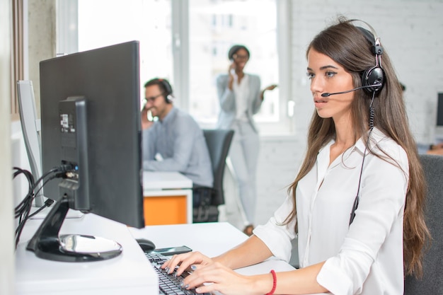 Mooie klantenservice operator die werkt in een callcenter kantoor