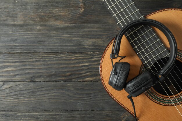 Mooie klassieke gitaar met koptelefoon op houten tafel