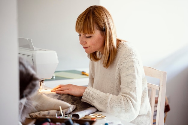 Foto mooie kleermaker naaien in haar atelier