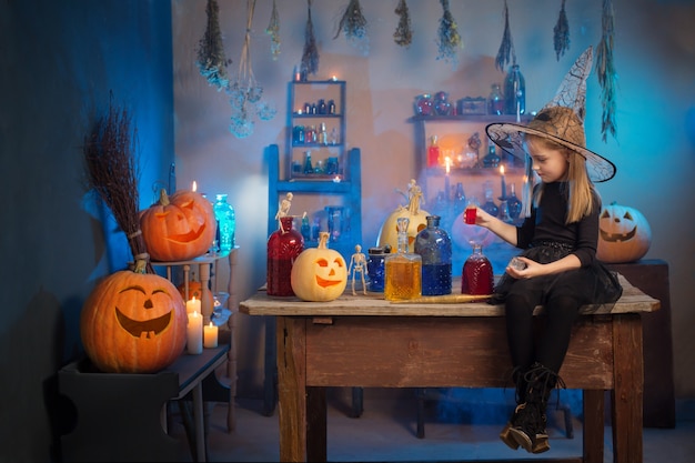 Mooie kleine heks met Halloween-versieringen