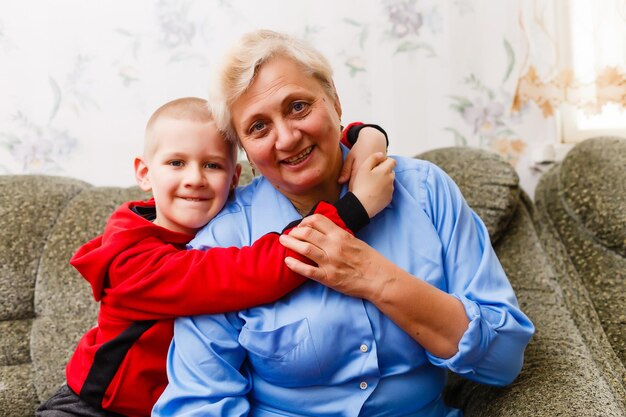 Mooie kleine jongen met zijn grootmoeder plezier en gelukkige momenten samen thuis