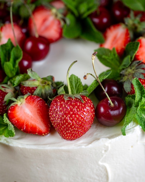 Mooie koektaart met witte room versierd met aardbeien en bosbessen