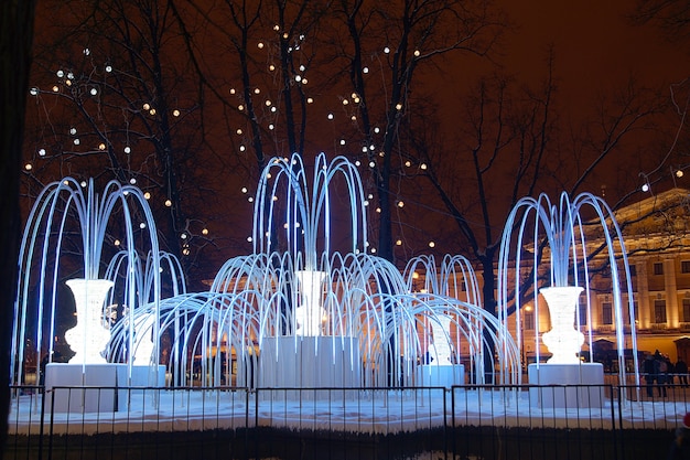 Foto mooie kunstmatige fontein met avondverlichting in de winter in de stad.