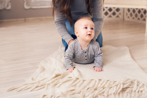 Mooie lachende schattige babyjongen met moeder
