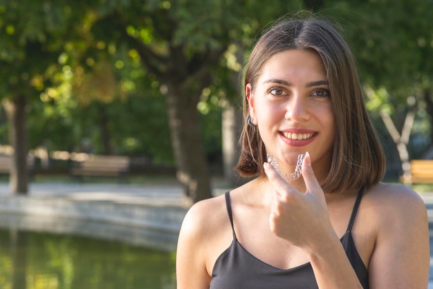 Mooie lachende Turkse vrouw houdt een invisalign bracer