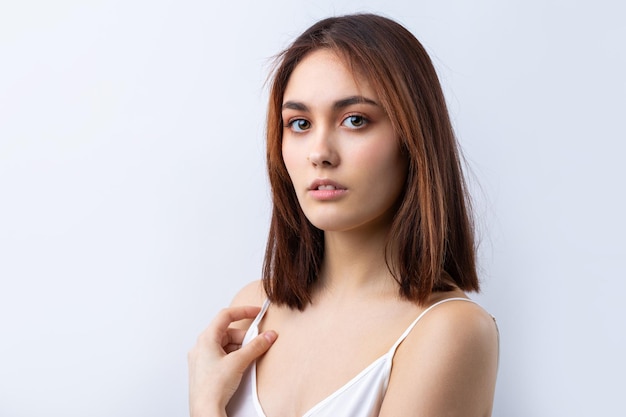 Mooie lachende vrouw met schone huid natuurlijke make-up en witte tanden op een grijze achtergrond