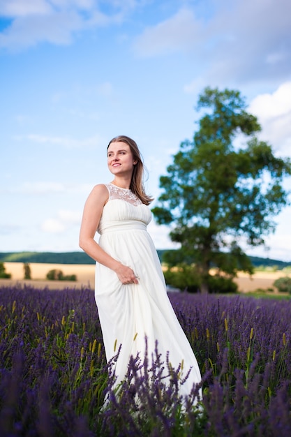 Mooie lachende zwangere vrouw op het veld