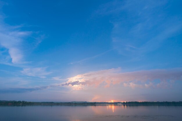 Mooie landschapshemel met wolken en kalme rivier Zonsopgang of zonsondergang