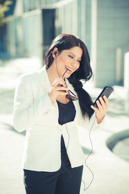 mooie lange zwarte haar elegante bedrijfsvrouw die smartphone gebruikt