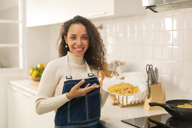 mooie Latijnse vrouw die in keuken kookt