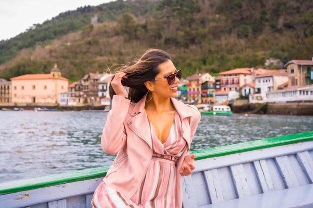 Mooie Latijnse vrouw met zonnebril sightseeing op een boot langs de kust Zomertoerisme op vakantiemodel dat plezier heeft op excursie