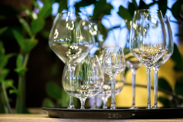 Mooie lege glazen bekers van verschillende formaten Een dienblad met glazen uit een restaurant