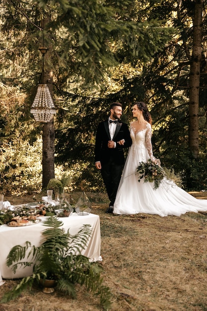 Mooie liefdevolle paar pasgetrouwden in het bos, bruiloft in de natuur