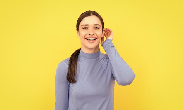 Mooie look van een jong meisje gezicht portret van dame op gele achtergrond drukt positieve emoties uit