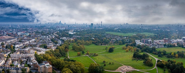 Mooie luchtfoto van Londen met veel groene parken en wolkenkrabbers van de stad op de voorgrond.