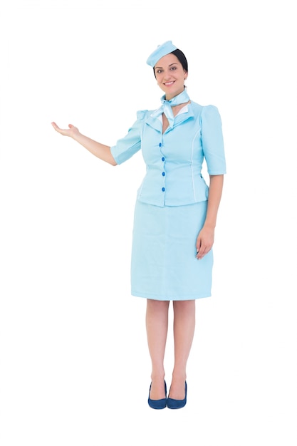 Mooie luchtstewardess die met hand toont