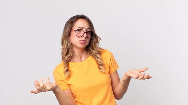 Mooie magere vrouw die haar schouders ophaalt met een domme, gekke, verwarde, verbaasde uitdrukking, geïrriteerd en geen idee