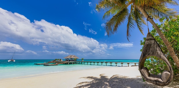 Mooie Malediven. Tropisch strandpanorama als zomerlandschap, paar strandschommel zeezandhemel