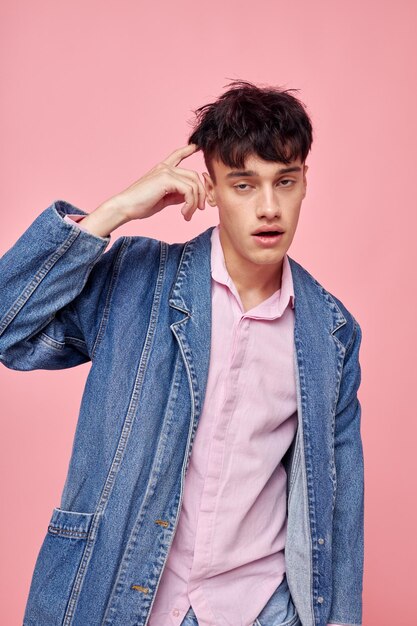 Foto mooie man in stijlvolle jeugdkleding spijkerjasje poseren roze achtergrond ongewijzigd