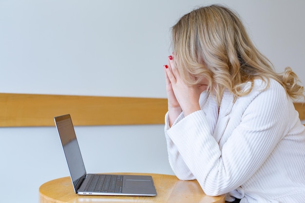 Mooie meid freelancer die zich moe en gestrest voelt terwijl ze een laptop gebruikt en op afstand werkt.